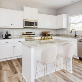 Spacious kitchens with thoughtful details Greenwood Apartments - Kitchen With Wood-Style Flooring, Modern Decor, Granite Countertops, Stainless Steel Appliances, Built-In Microwave, Kitchen Island, And Dishwasher.